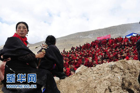 一位藏族妇女在法会上摇动转经筒